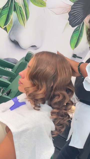 Client mid-style in the emerald salon chair